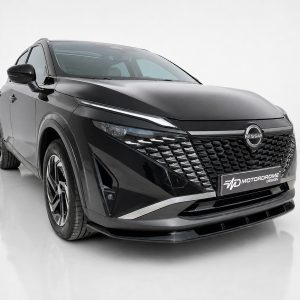 Black Nissan SUV in a studio setting, shown from a front three-quarter angle with a glossy grille and badge visible.