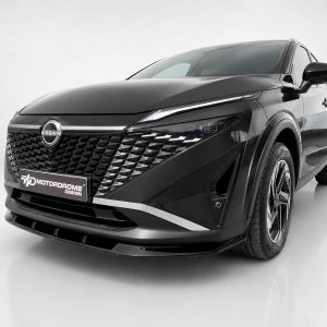 Three-quarter front view of a black Nissan SUV in a studio, highlighting the intricate diamond grille and chrome accents.