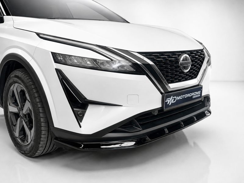 Front-left view of a white Nissan SUV: prominent grille, sleek headlight, and alloy wheel visible; shows car brand badge.