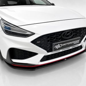 Front view of a white Hyundai with a black honeycomb grille, headlight on the left, and a red-accent lip under the bumper.