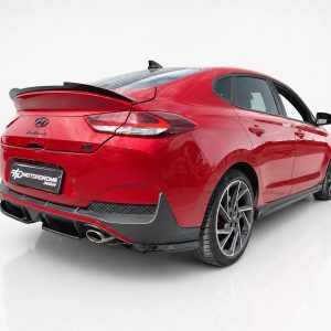 K180-005_2jpg - OPSHOLDERS Red Hyundai sedan viewed from rear-right in a studio setup, featuring a spoiler and sporty black rear bumper accents.