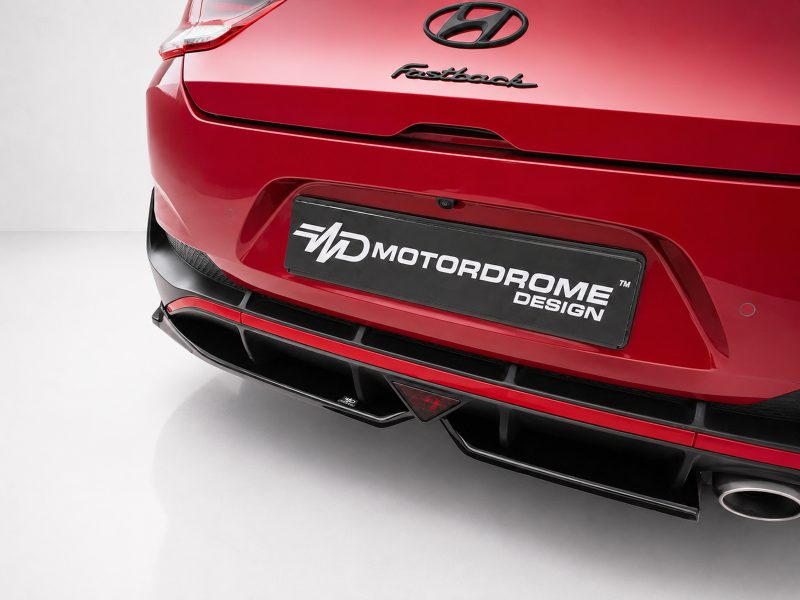 K180-005_4jpg - OPSHOLDERS Rear view of a red Hyundai Fastback with a black license-plate reading 'MotorDome Design' and Hyundai emblem above it.