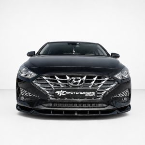 Front view of a black Hyundai sedan with a chrome grille and 'Motordrome Design' license plate badge in a studio setting