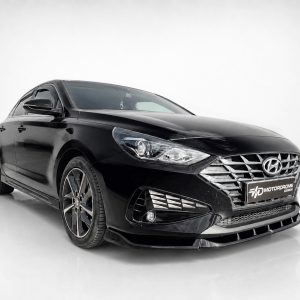 Black Hyundai sedan in a clean studio setting, front-right angle showing chrome grille and stylish headlights
