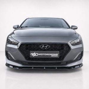 Front view of a gray sedan with a large black mesh grille and Hyundai emblem; 'Motordrome Design' plate visible on the bumper.