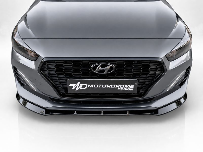 Front view of a metallic gray Hyundai with a black honeycomb grille and a Motordrome Design plate on the bumper.