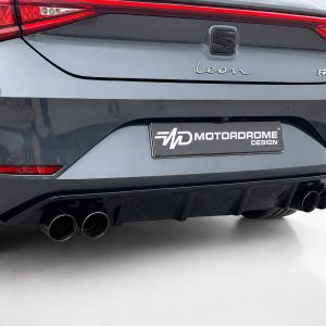 Rear view of a gray SEAT Leon FR showing red taillights, badge, and four exhaust tips above a Motordrome Design plate
