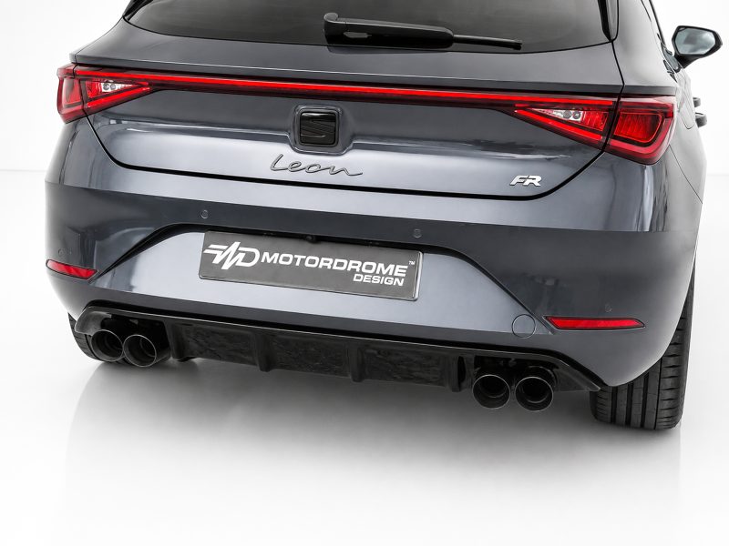 Rear view of a gray SEAT Leon hatchback with a red taillight strip, 'Leon' badge, and dual exhausts; Motordrome Design plate visible on the bumper