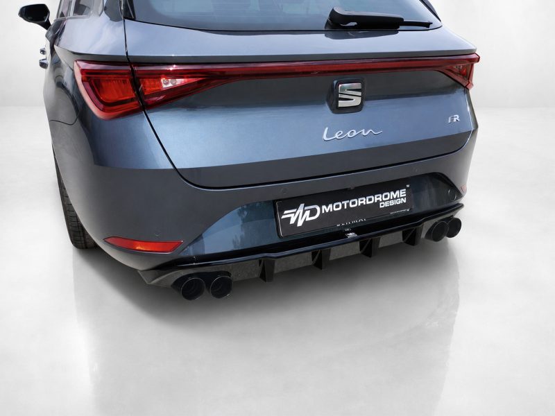 Rear view of a blue SEAT Leon FR with aftermarket Motordrome Design license plate and quad exhausts at the diffuser tail.