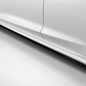 Side view of a white car showing the door seam and lower body panel with a side skirt running along the bottom edge
