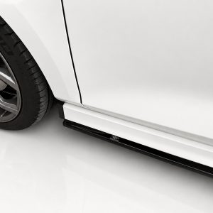 Close-up of a car's front wheel with alloy rim and tire, showing the wheel well and lower side skirt.