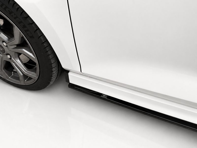 Close-up of a car's front wheel with alloy rim and tire, showing the wheel well and lower side skirt.