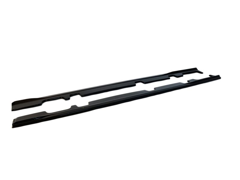 Two black long car rocker-panel trim pieces laid on a white background.