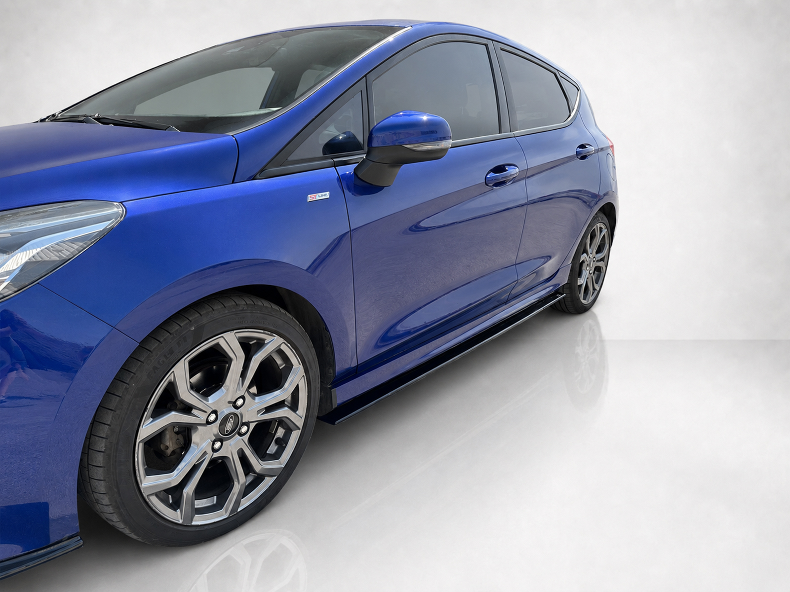 K182-005_2jpg - OPSHOLDERS Blue hatchback shown from the front-left side with alloy wheels and a sleek mirror. (informative)