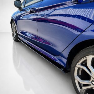 K182-005_4jpg - OPSHOLDERS Close-up of a blue car's side, showing the door, glossy paint, and front wheel rim.