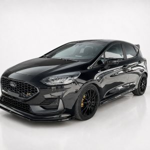 Black Ford performance hatchback with a low stance, honeycomb grille, and large black wheels in a studio setting.