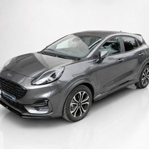 Front three-quarter view of a metallic gray compact SUV in a studio, showing the grille, headlights, and alloy wheels.