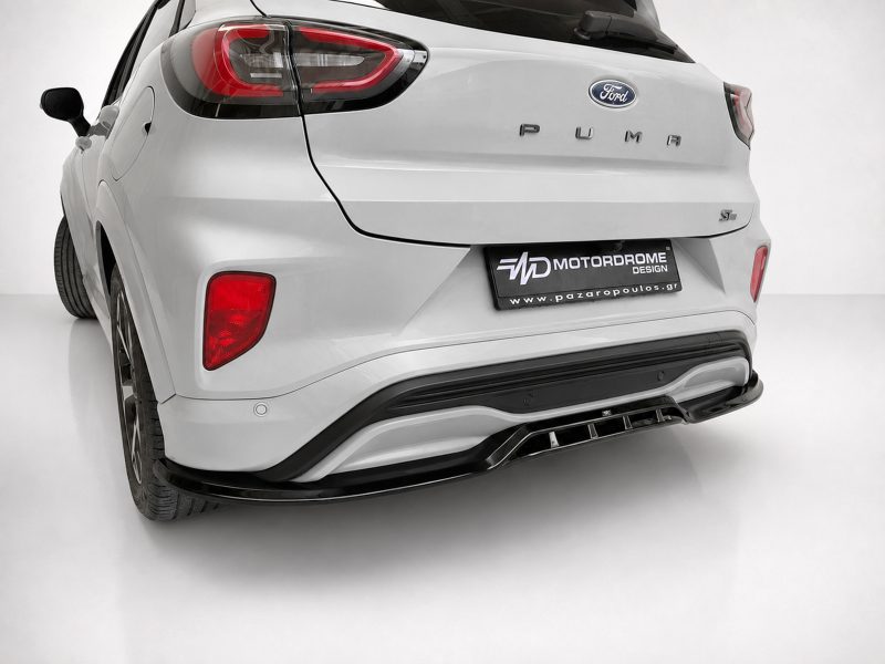 Rear view of a white Ford SUV showing taillights and a black Motordrome Design license plate on the bumper