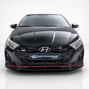 Front view of a black Hyundai car in a studio, license plate reads 'Motordrome Design' with red lower lip detail under the bumper
