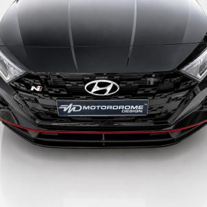 Front view of a glossy black Hyundai with a large grille, Hyundai emblem center, N badge on the left, and a red accent line along the lower bumper; license plate reads MOTORDROME DESIGN.
