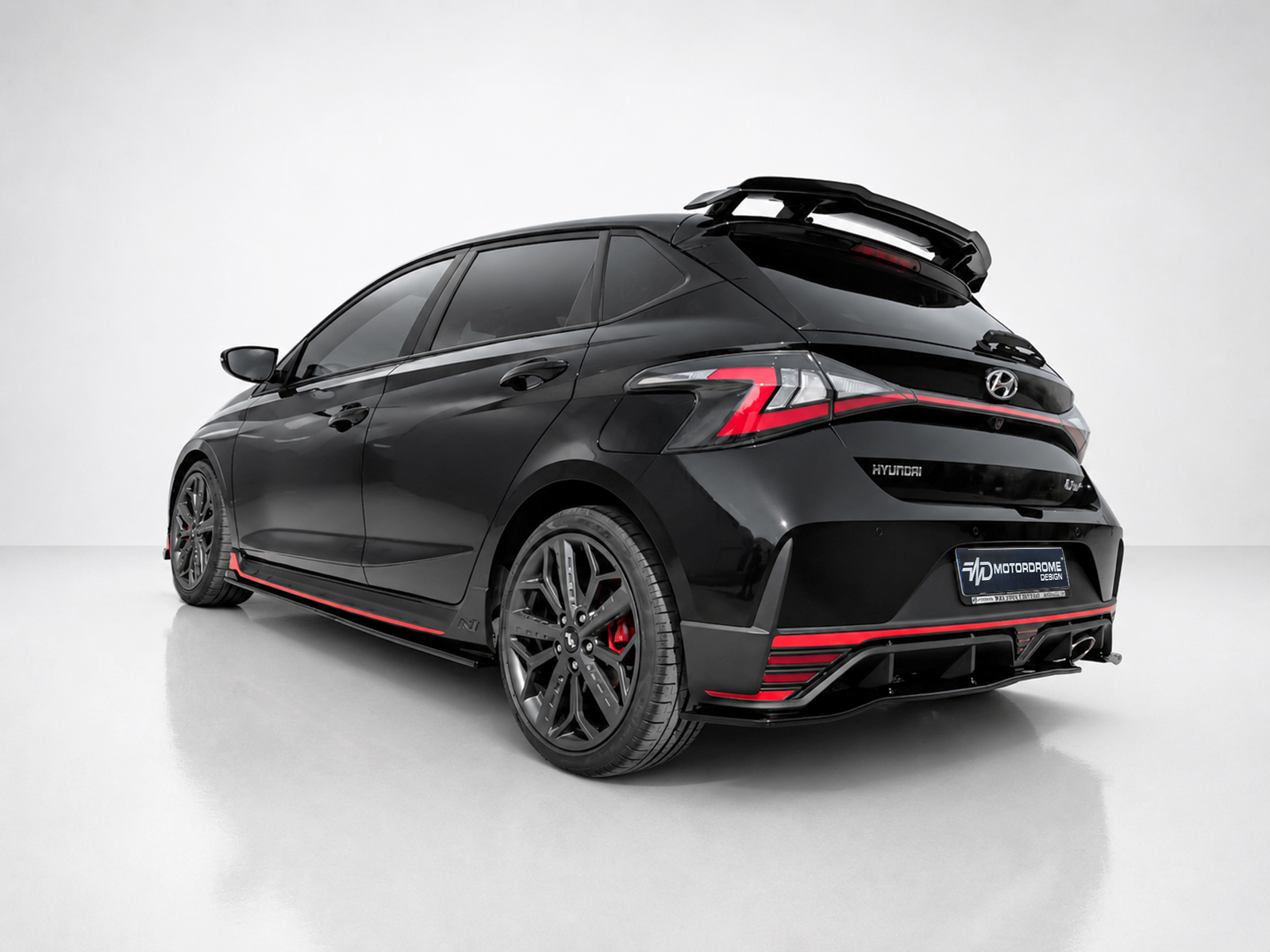 K185-003_2jpg - OPSHOLDERS Black Hyundai hatchback with red trim and rear spoiler parked in a light studio environment.