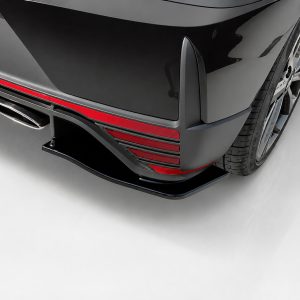 K185-003_5jpg - OPSHOLDERS Rear view of a black sports car with red trim, diffuser, and exposed exhaust tip in the lower bumper area, near a wheel.