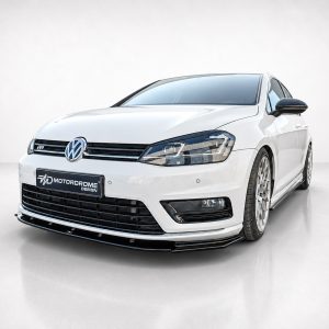 White Volkswagen car shown from a front-left three-quarter angle in a studio, featuring a black grille and aftermarket front lip.