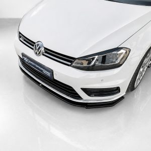 Front-left angled view of a white Volkswagen car, displaying the emblem, grille, and headlight.