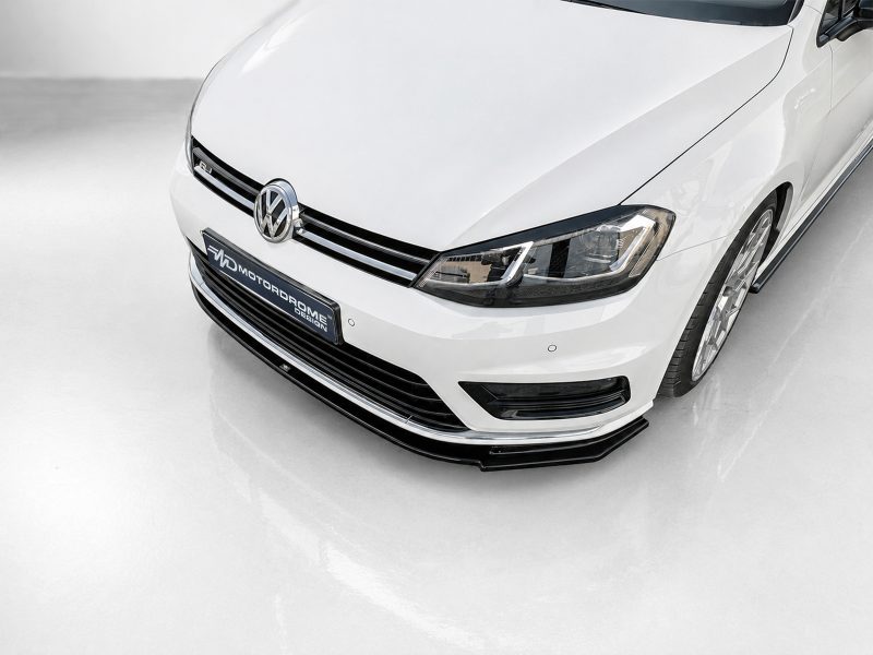 Front-left angled view of a white Volkswagen car, displaying the emblem, grille, and headlight.