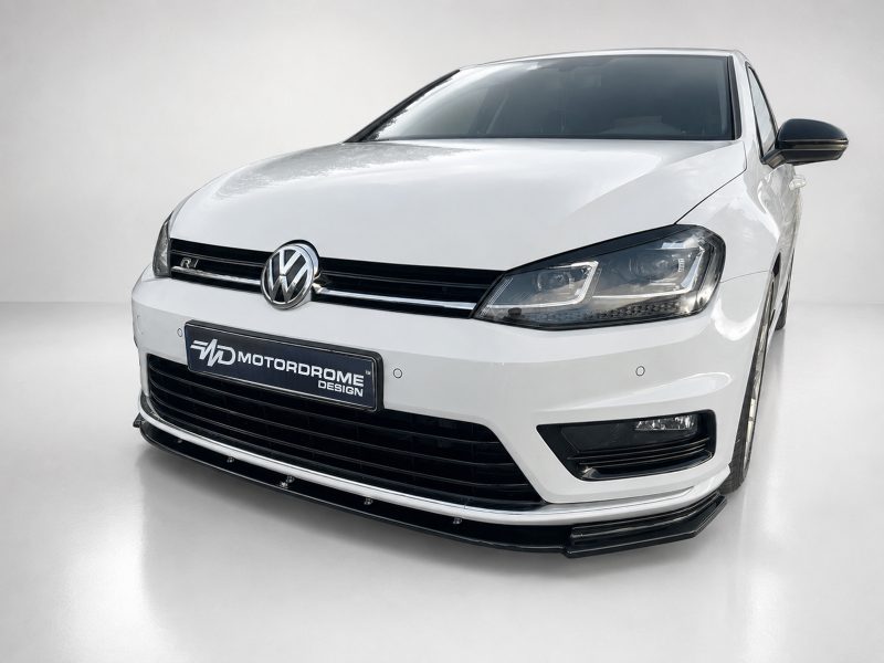 Front view of a white Volkswagen sedan with black grille and emblem on a showroom floor