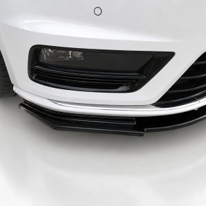 Front lower section of a white car showing a black grille, bumper lip, and chrome accent near the ground, with a tire visible on the left.