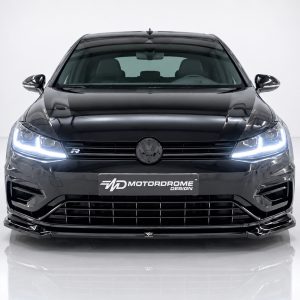Front view of a black Volkswagen with illuminated LED headlights, prominent grille, and a Motordrome Design plate on the bumper.