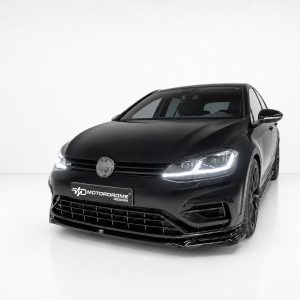 Black sport sedan shown in a three-quarter front view on a white studio backdrop, with a Motordrome Design plate on the bumper