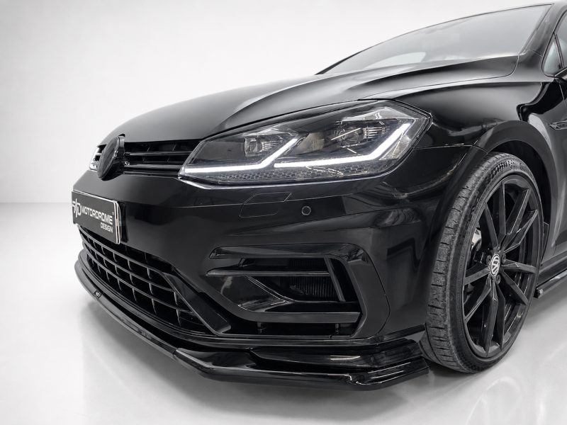 Front-left angle of a glossy black car showing the headlight, grille, and lower bumper details, with a sleek modern design.]