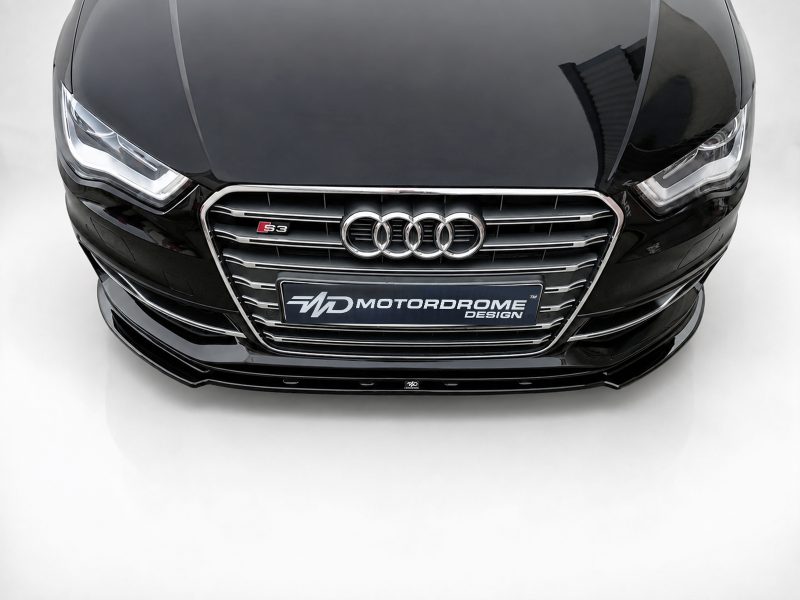 Front view of a black Audi car showing the four-ring emblem and S3 badge on a chrome grille, with headlights visible on either side corporate lighting.