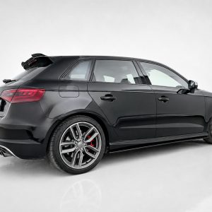 Side-rear view of a black station wagon with large alloy wheels and red brake calipers