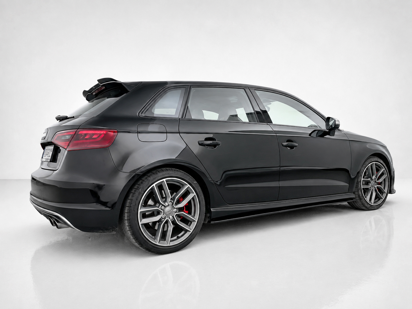 K187-002_1jpg - OPSHOLDERS Side-rear view of a black station wagon with large alloy wheels and red brake calipers