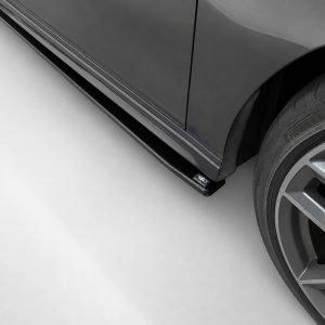 K187-002_4jpg - OPSHOLDERS Close-up of a dark gray car's lower side and wheel, showing a large alloy rim and a Pirelli tire; a small 4WD badge is visible on the side skirt