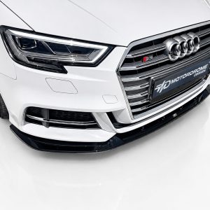 Front view of a white Audi S3, highlighting the chrome grille and futuristic headlight design.