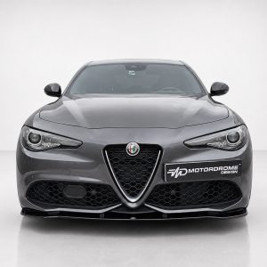 Front view of a gray Alfa Romeo car in a studio setting, showcasing the hexagonal grille and distinctive headlights with a MotorDrome Design plate on the bumper.