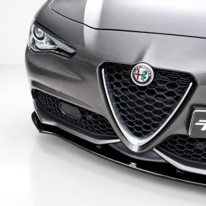 Front view of a dark gray Alfa Romeo with honeycomb grille and circular badge prominently displayed on the hood.