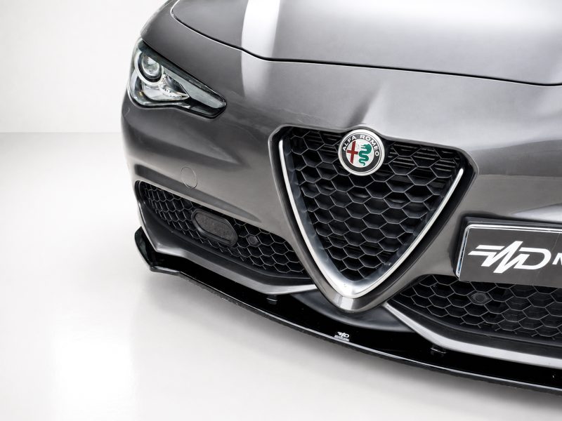 Front view of a dark gray Alfa Romeo with honeycomb grille and circular badge prominently displayed on the hood.