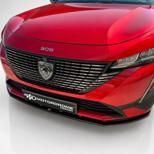 Red Peugeot 308 front view showcasing its chrome grille and emblem, headlights, and sporty bumper detail in a showroom setting