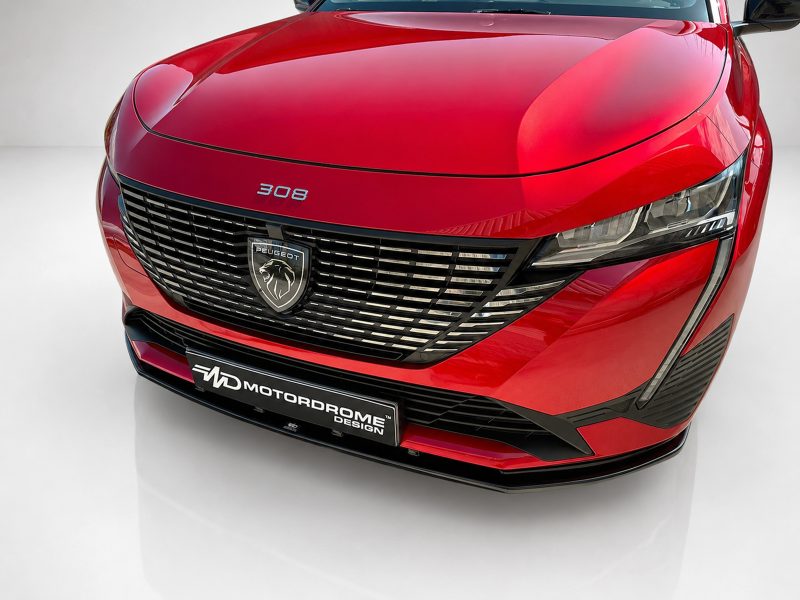 Red Peugeot 308 front view showcasing its chrome grille and emblem, headlights, and sporty bumper detail in a showroom setting