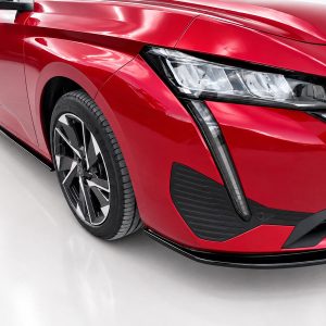 Close-up of a glossy red car's front left area, showing the headlight, grille, and alloy wheel still in view