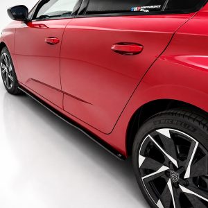 Close-up of a glossy red car door and front fender, with a large black alloy wheel visible on the right side.