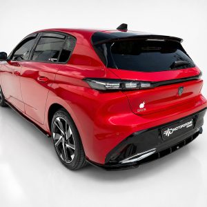 K189-003_5jpg - OPSHOLDERS Red compact hatchback photographed from a rear three-quarter angle, showing a black roof spoiler, dark rear window, and large alloy wheels in a studio setting
