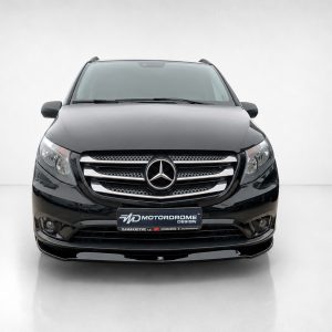 Front view of a black Mercedes SUV showing the grille with the Mercedes emblem and sleek headlights in a studio setting