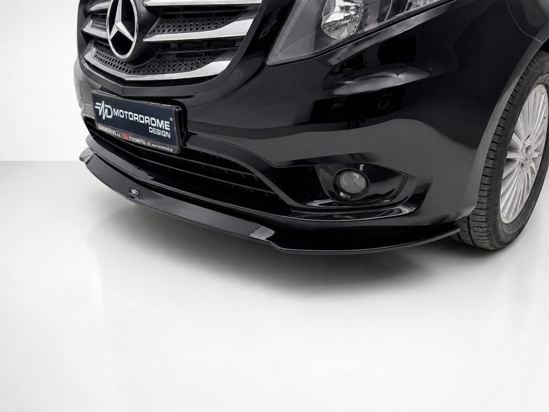 Front-left portion of a glossy black car; visible Mercedes grille, headlight, and a custom MOTORDROME DESIGN plate on the bumper.