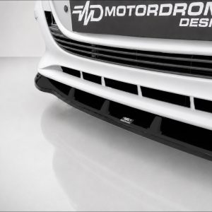 K190-002_4jpg - OPSHOLDERS Close-up of a white car front showing a black grille and 'Motordrome Design' branding plate on the bumper.